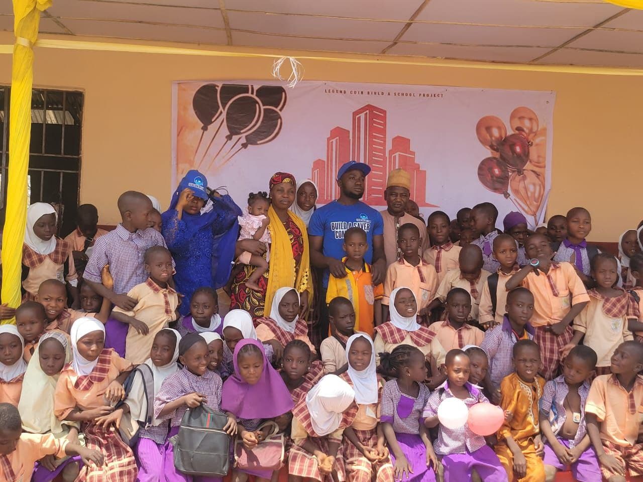 Large group photo of children families and supporters at the new school